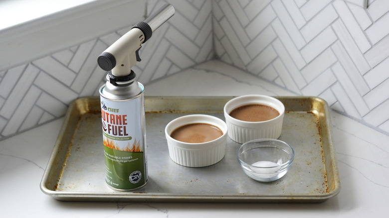 two chocolate creme brulees with butane kitchen torch 