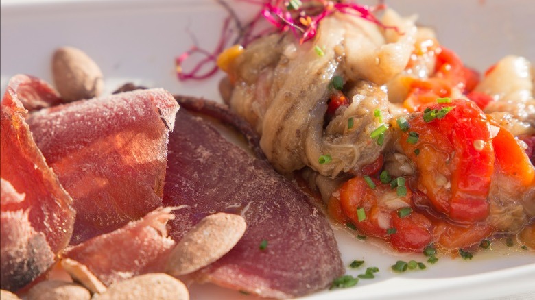 Sliced dried mojama with almonds and tomato and anchovy