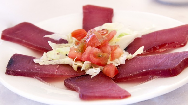 Spanish salt-cured tuna called mojama with diced tomatoes