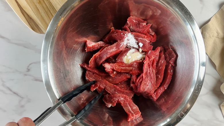 raw steak in bowl with marinade