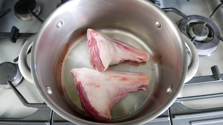 raw lamb shanks in pan