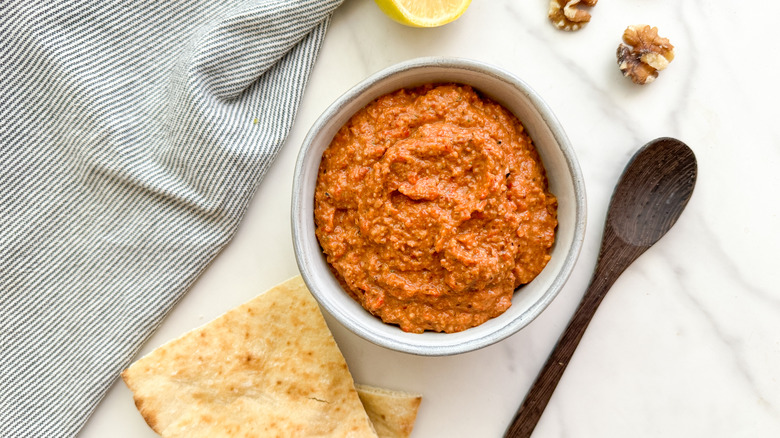 bowl of muhammara dip with pita