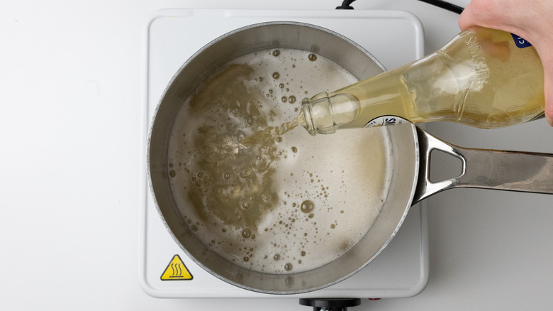 cider being poured into saucepan 