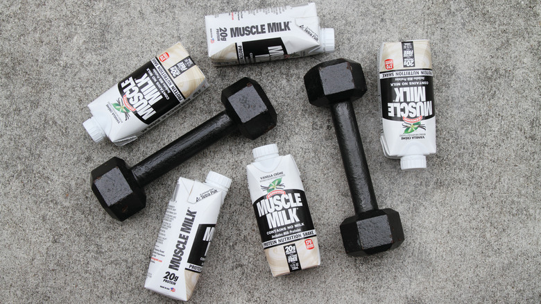 Bottles of muscle milk with dumbbells 