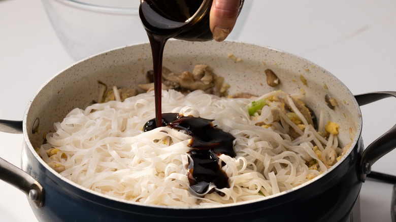 Pouring sauce on noodles 