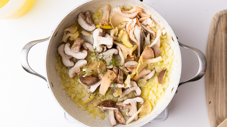 onions, mushrooms and herbs cooking in a pan