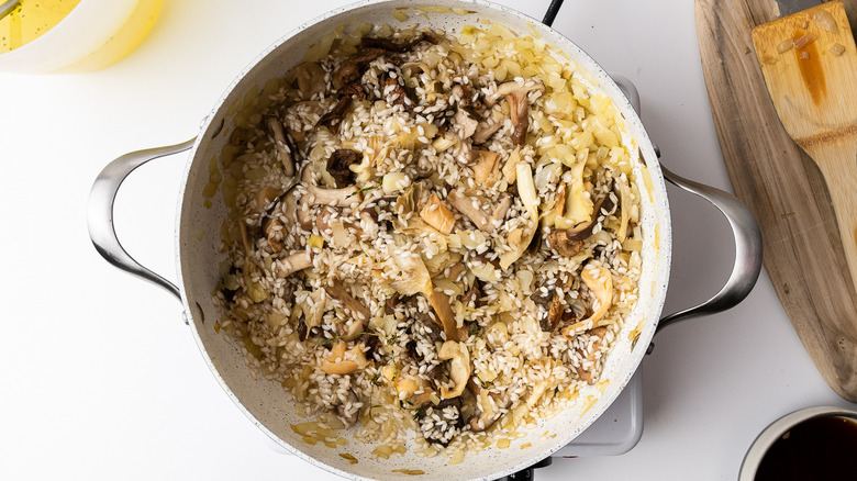 mushrooms, onions and arborio rice in a pan 