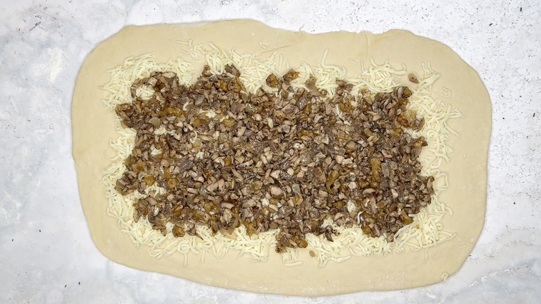 mushroom mixture scattered over dough