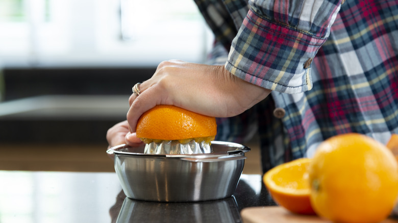 Woman juicing fresh oranges