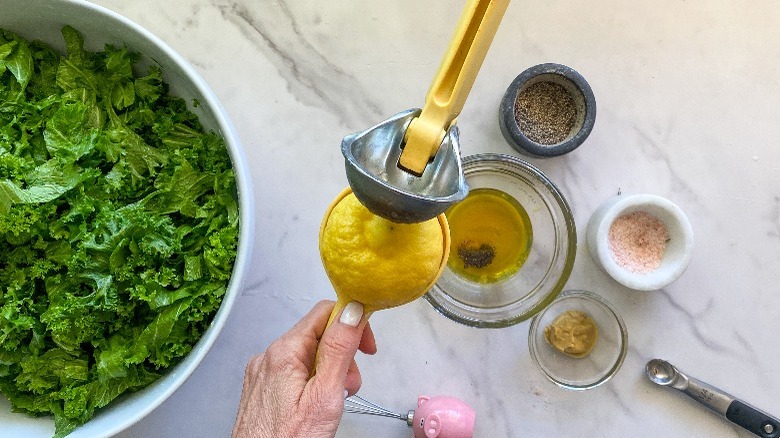 small bowls with dressing ingredients and lemon squeezer