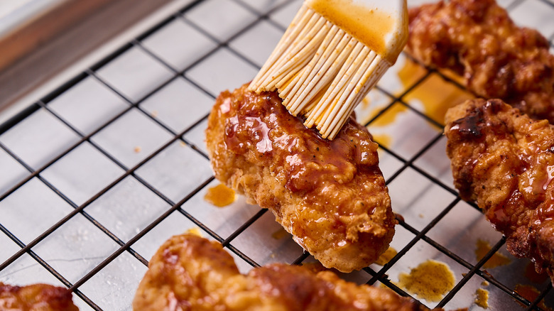 brushing chicken with nashville hot sauce