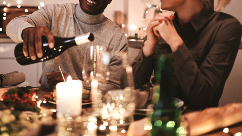 guests serving wine at dinner party