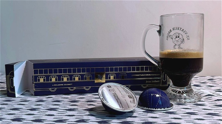 A cup of Nespresso Unforgettable Double Espresso next to pods and sleeve