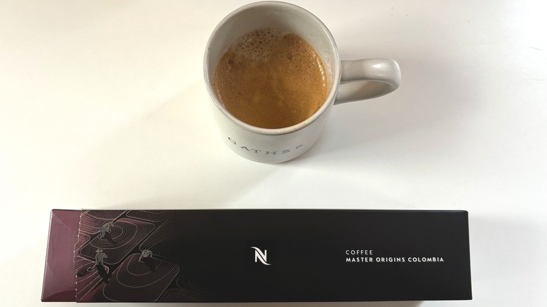 A mug of Nespresso Master Origins Colombia coffee above a box of pods