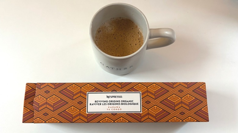 A cup of Nespresso Kahawa ya Congo coffee above a brown box of pods