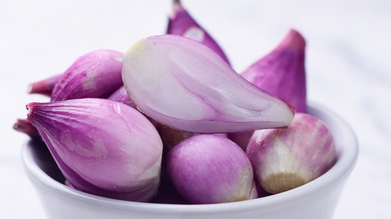 peeled shallots in a white bowl