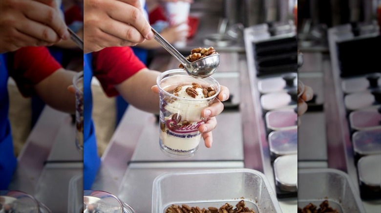 Caliche's employee putting nuts on sundae