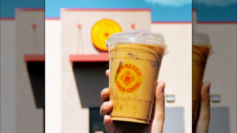 Person holding a cup of New Mexico Piñon Coffee