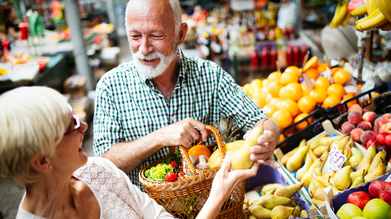 Older couple buying vegetables 