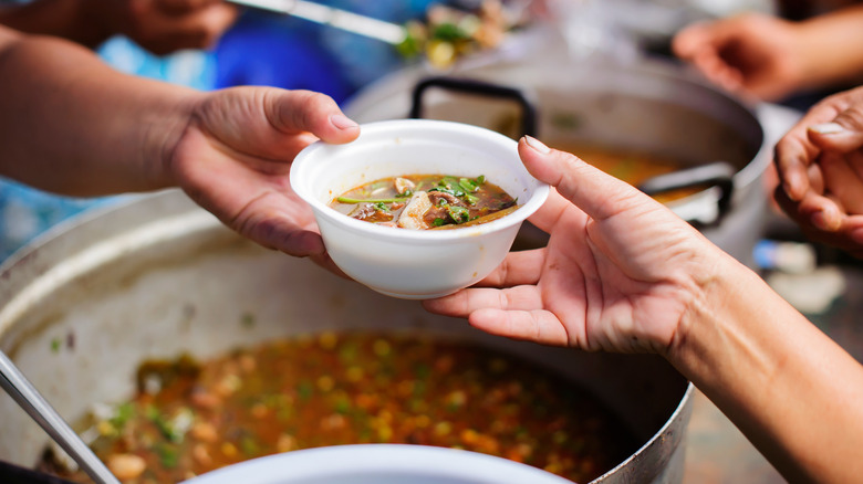 handing a bowl of soup