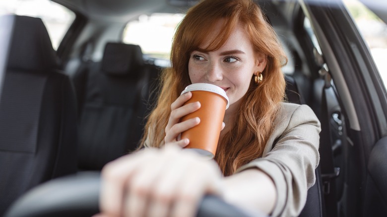 woman drinking coffee in car