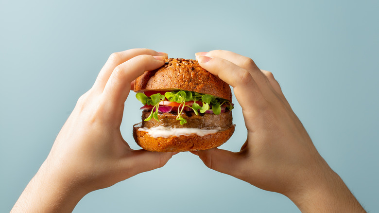 Hands holding a plant-based burger 