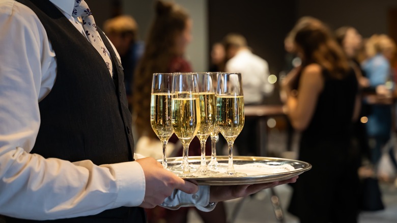 waiter carrying tray of Champagne