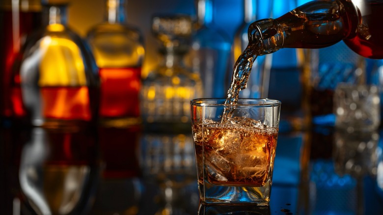 Bourbon pouring from a bottle into a glass