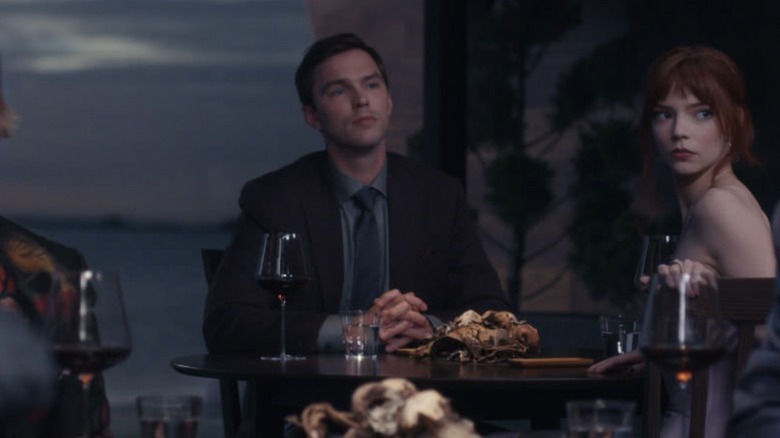 Nicholas Hoult and Anya Taylor-Joy sitting at a table in The Menu