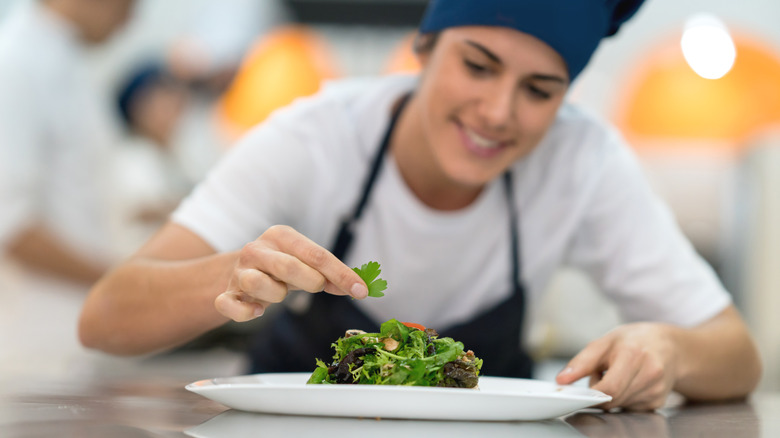 Culinary student plating a dish