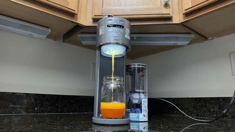 A Ninja Thirsti Max soda maker makes orange soda.