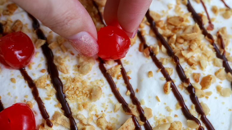 cherries being placed on top of a cake