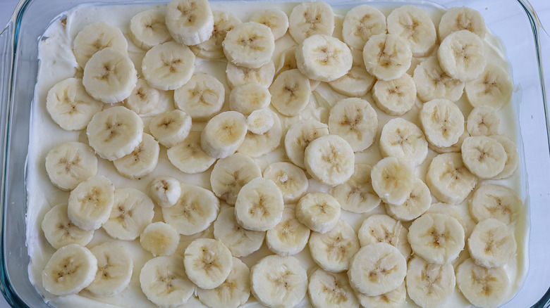 bananas over a cream cheese filling in a pan