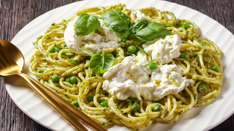 Torn mozzarella on pesto spaghetti