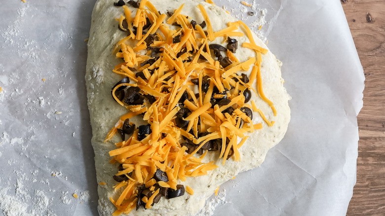 olives and cheese on folded dough