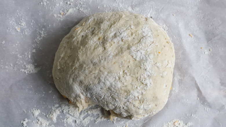 bread dough in a ball on parchment paper