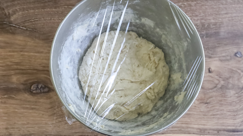 dough in a bowl with plastic over it