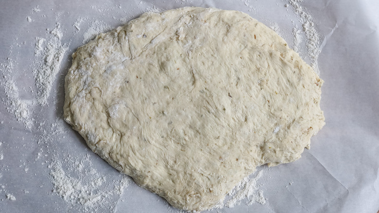 dough flattened on parchment paper