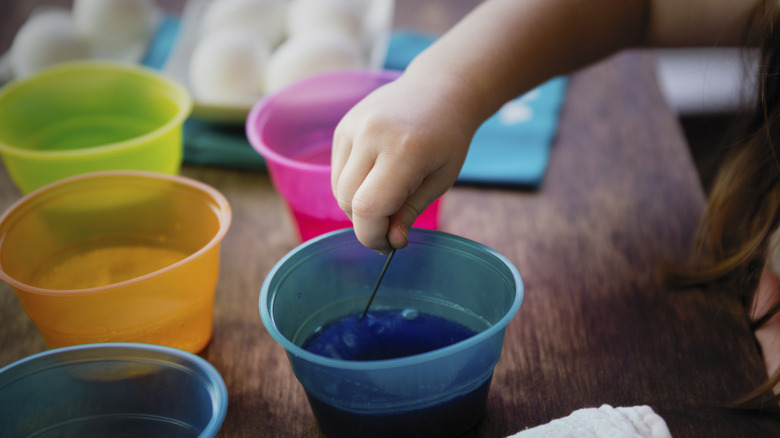 Pour food coloring into cups