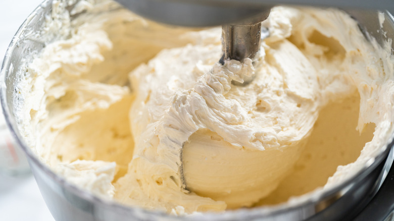 Butter being creamed in a big silver bowl.