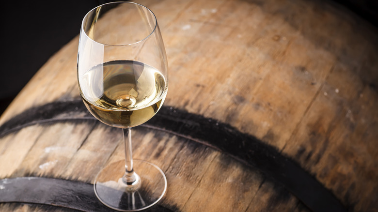 Glass of chardonnay on barrel