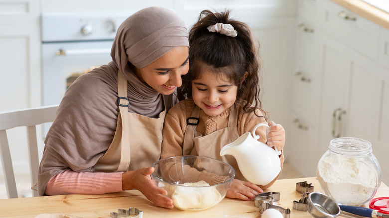 mother and daughter pouring milk