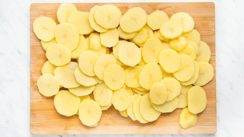 sliced potatoes on wooden board