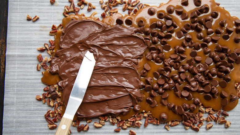 spreading melted chocolate on toffee