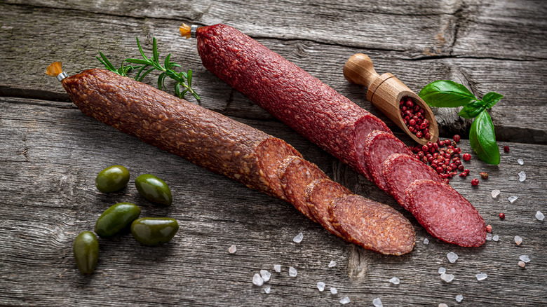 Salami logs on wooden table