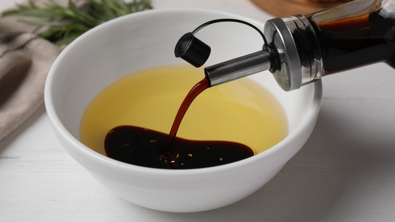 pouring vinegar into bowl of oil