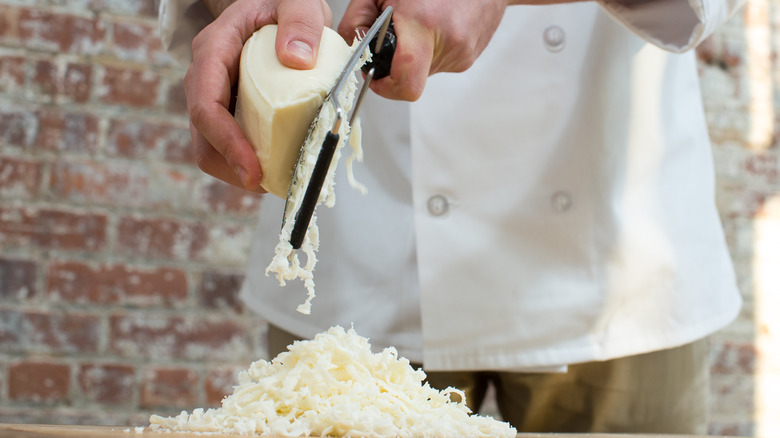 chef grating cheese into a pile