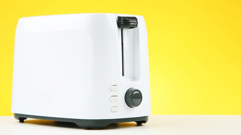 white toaster on countertop with yellow background