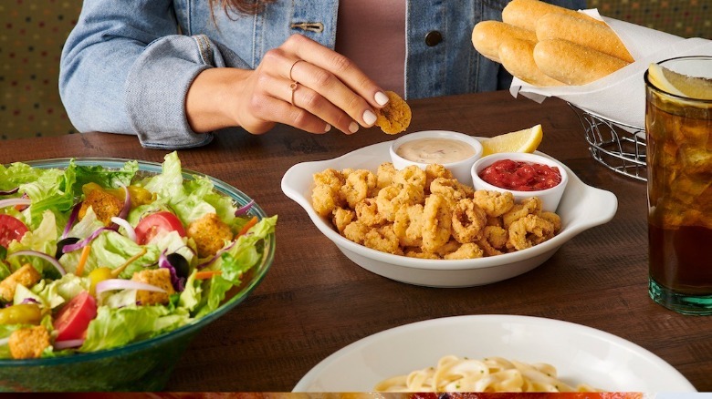 person eating appetizer and salad at Olive Garden