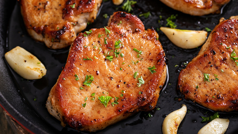 pork chops in a pan with garlic